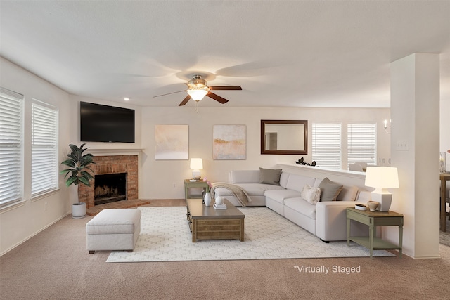 carpeted living room featuring a fireplace and ceiling fan