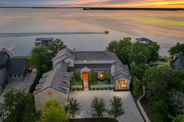 aerial view at dusk featuring a water view