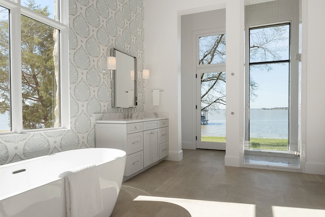 bathroom with vanity, a water view, and a wealth of natural light