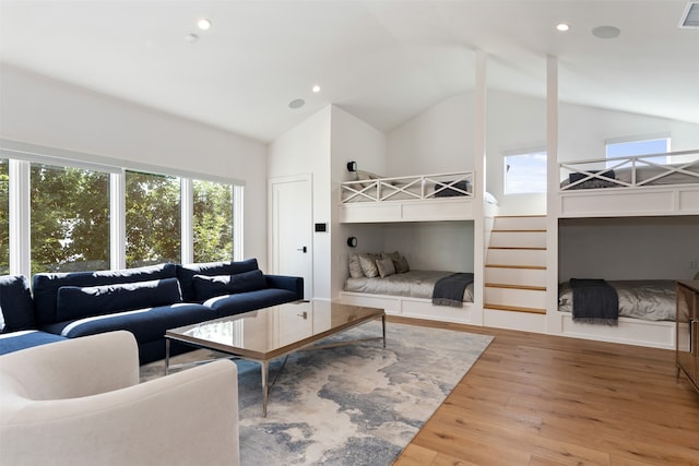 living room with high vaulted ceiling and light wood-type flooring