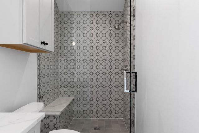 bathroom featuring vanity, tiled shower, and toilet