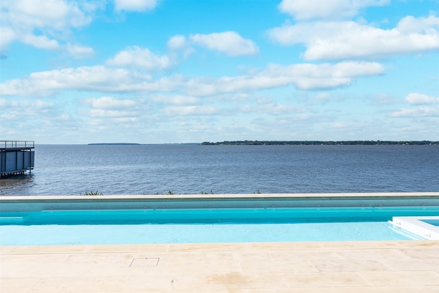 view of swimming pool featuring a water view