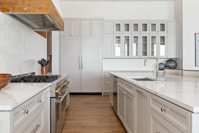 455 Sun Vly, Mabank, TX 75147 - kitchen featuring stainless steel appliances, wall chimney range hood, a sink, light wood-type flooring, and white cabinets