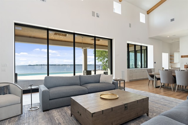 living room featuring wood-type flooring, a healthy amount of sunlight, and a water view