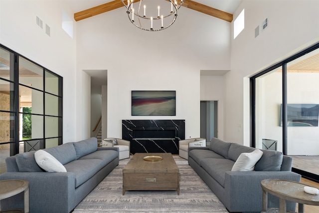 living room with high vaulted ceiling, beamed ceiling, and a chandelier