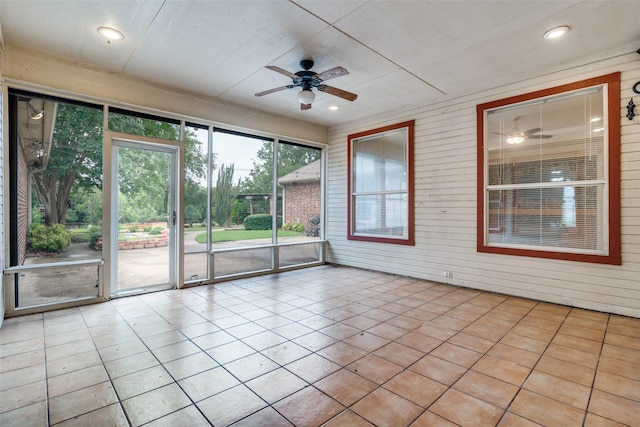 unfurnished sunroom featuring ceiling fan