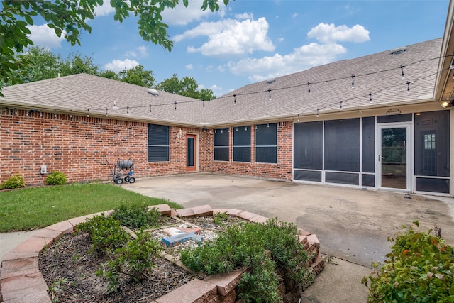 rear view of house featuring a lawn and a patio