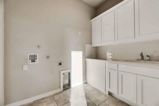 clothes washing area with sink, cabinets, electric dryer hookup, gas dryer hookup, and light tile patterned floors