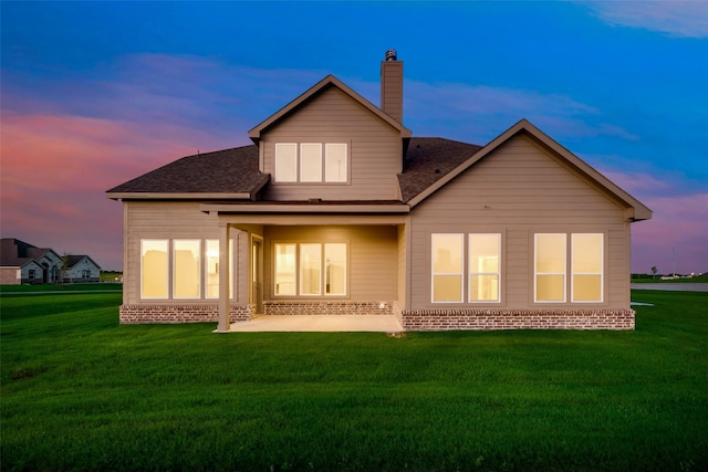 back house at dusk with a yard