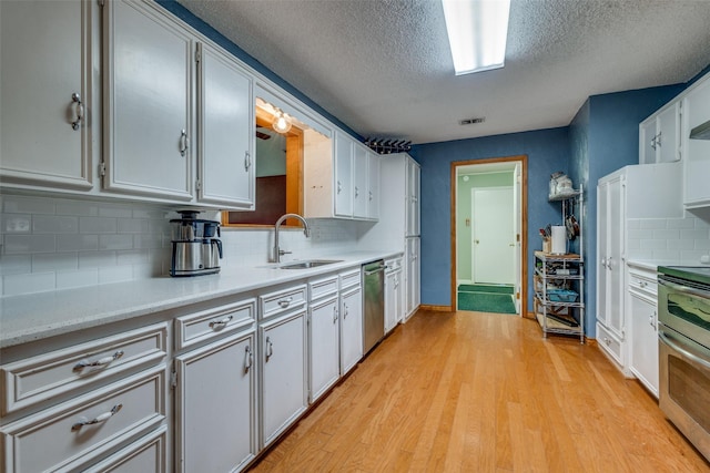 kitchen featuring tasteful backsplash, white cabinetry, sink, and stainless steel appliances