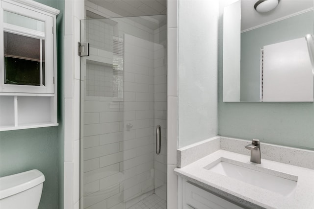 bathroom featuring vanity, toilet, an enclosed shower, and ornamental molding