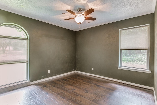 empty room with a textured ceiling, crown molding, ceiling fan, and dark wood-type flooring