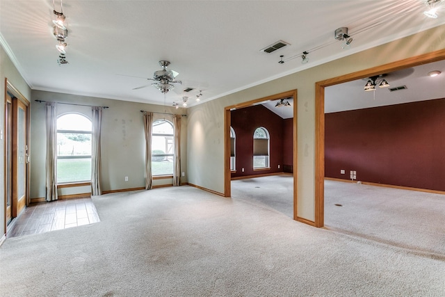 carpeted empty room with ceiling fan, ornamental molding, and track lighting