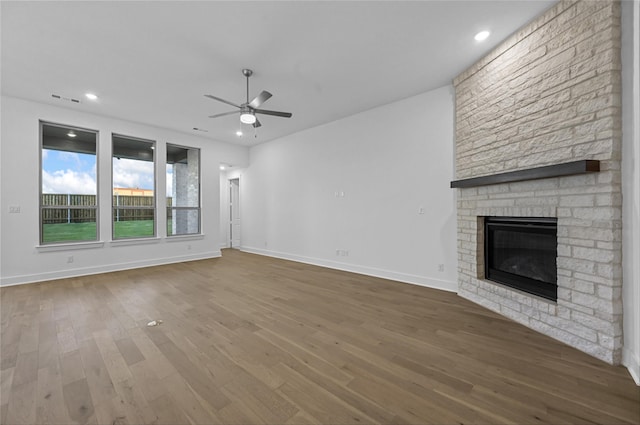 unfurnished living room with a fireplace, wood-type flooring, and ceiling fan