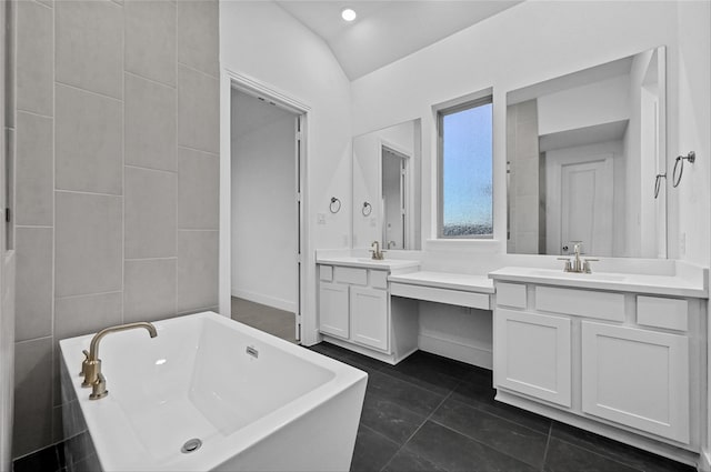 bathroom featuring a bathing tub, tile patterned flooring, vanity, and lofted ceiling