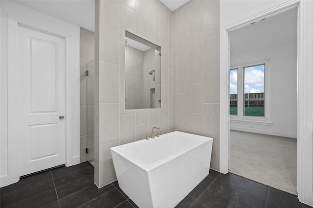 bathroom featuring plus walk in shower, tile patterned floors, and tile walls