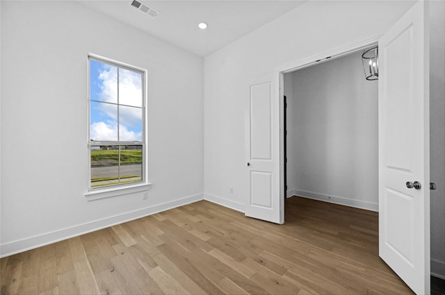 unfurnished bedroom with light wood-type flooring and multiple windows