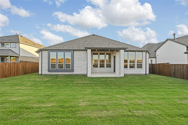 rear view of house featuring a yard and a patio