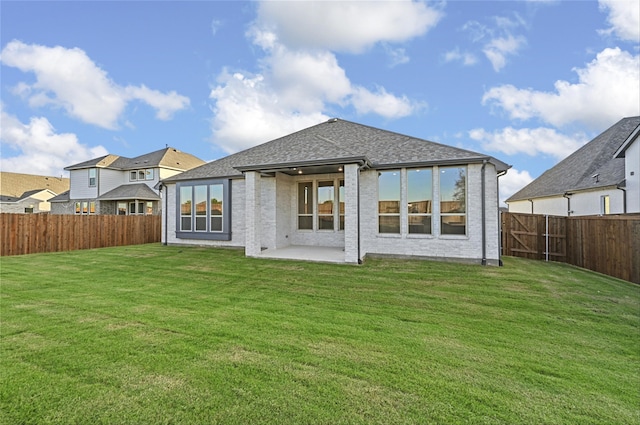 rear view of property featuring a lawn and a patio area