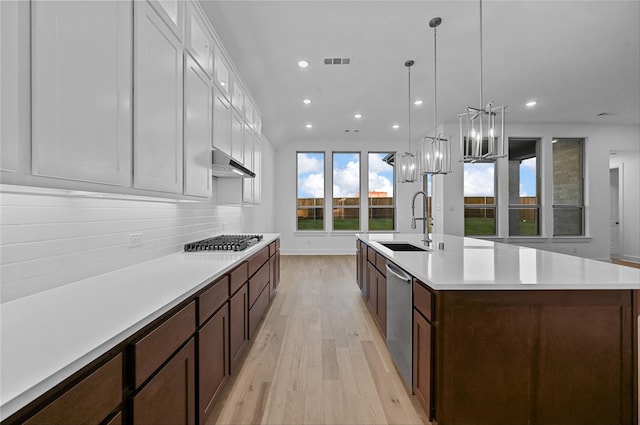 kitchen featuring a spacious island, white cabinets, stainless steel appliances, and light wood-type flooring