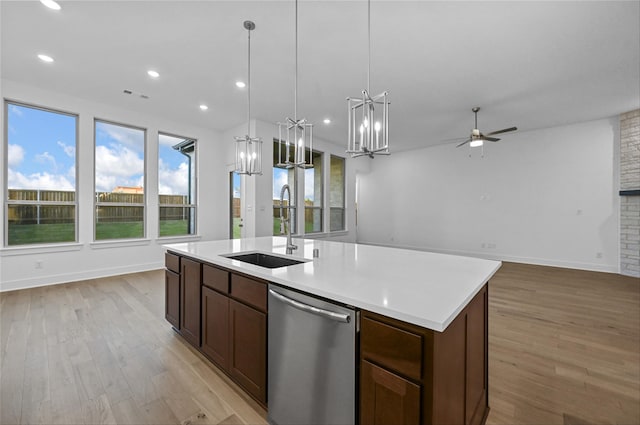 kitchen with sink, stainless steel dishwasher, a center island with sink, and light wood-type flooring