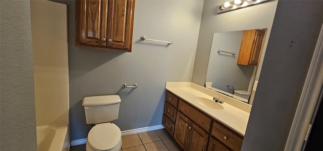 full bathroom with vanity, a tub, toilet, baseboards, and tile patterned flooring