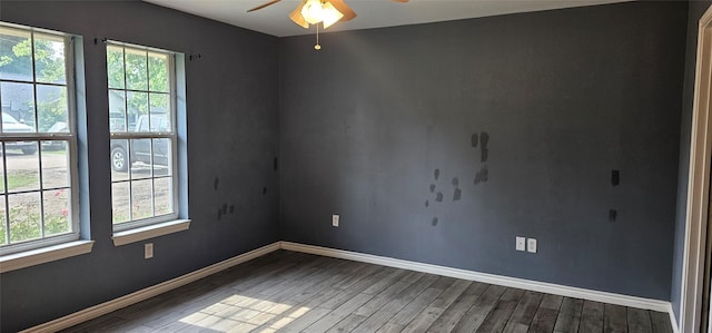 empty room featuring baseboards, wood finished floors, a healthy amount of sunlight, and ceiling fan