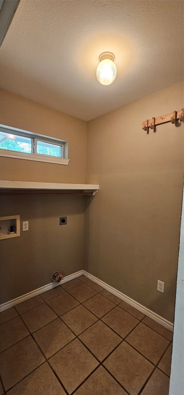 clothes washing area featuring tile floors, a textured ceiling, hookup for a washing machine, and electric dryer hookup