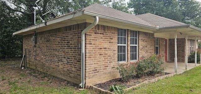 view of side of property featuring a patio and brick siding