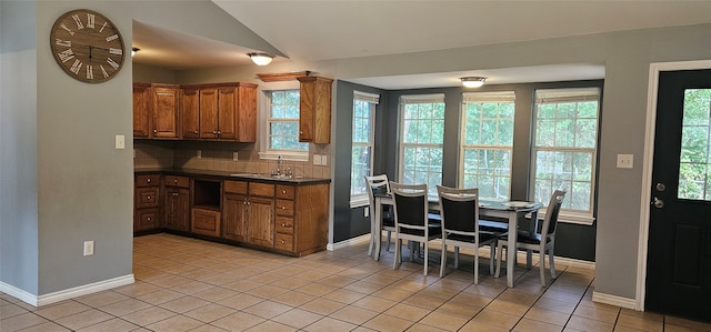 kitchen featuring sink, tasteful backsplash, and light tile flooring