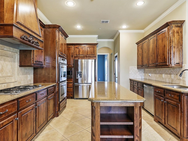 kitchen featuring light stone countertops, tasteful backsplash, stainless steel appliances, sink, and a center island