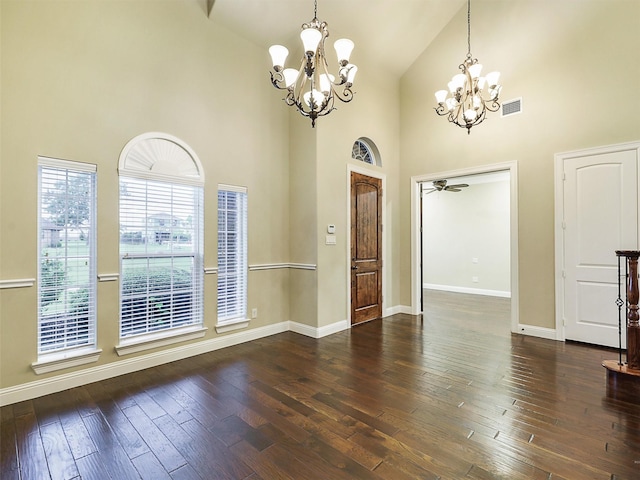 interior space with dark hardwood / wood-style flooring, high vaulted ceiling, and ceiling fan with notable chandelier