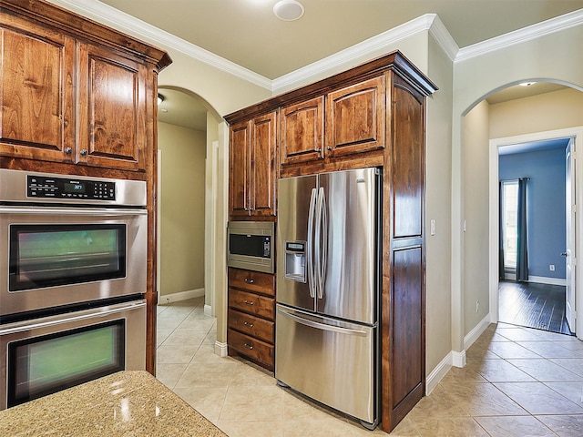 kitchen featuring light tile patterned floors, stainless steel appliances, light stone counters, and crown molding