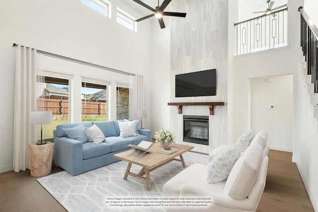 living room with hardwood / wood-style flooring, plenty of natural light, a large fireplace, and ceiling fan