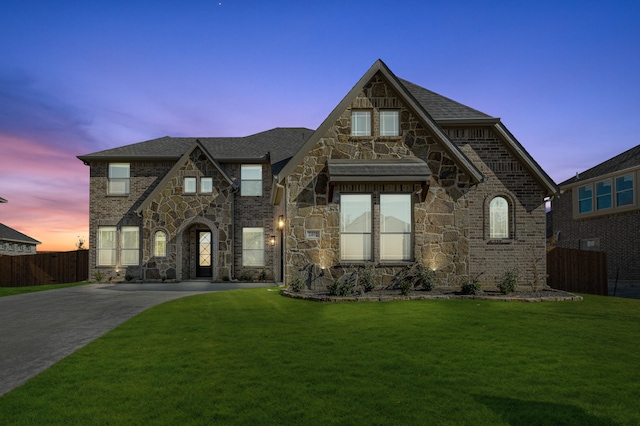 english style home featuring a yard