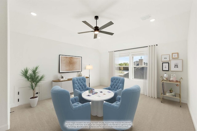 living area featuring light colored carpet and ceiling fan