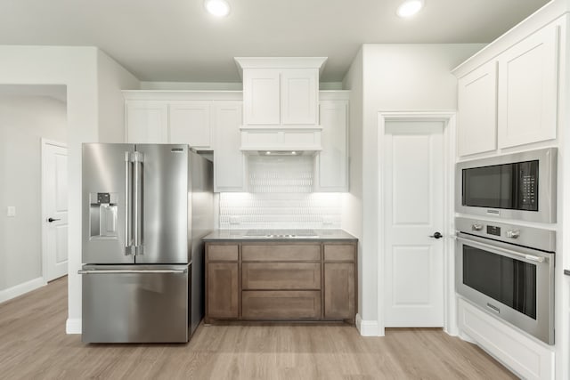 kitchen with white cabinets, black appliances, and light hardwood / wood-style floors