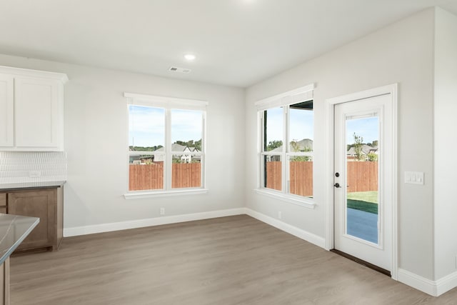 unfurnished dining area with light hardwood / wood-style flooring