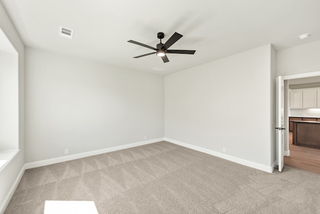 carpeted empty room featuring ceiling fan