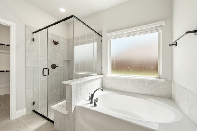 bathroom with independent shower and bath and tile patterned floors