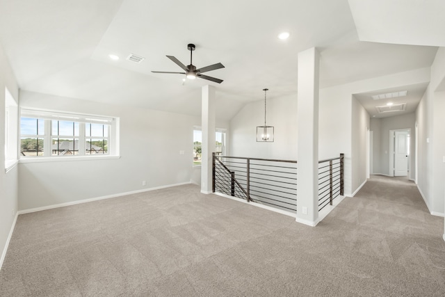 carpeted spare room featuring ceiling fan and vaulted ceiling