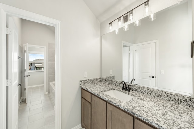 bathroom with vanity, lofted ceiling, and tile patterned floors