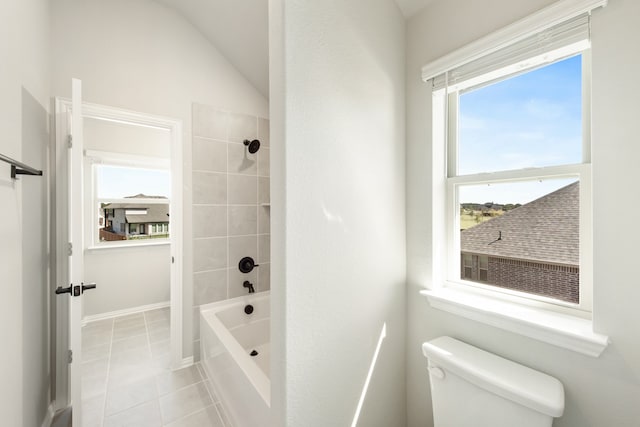 bathroom featuring lofted ceiling, tiled shower / bath combo, tile patterned flooring, and toilet