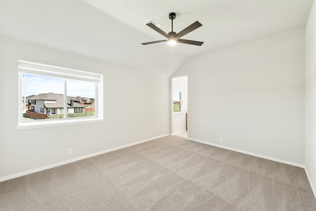 spare room featuring vaulted ceiling, ceiling fan, and light colored carpet