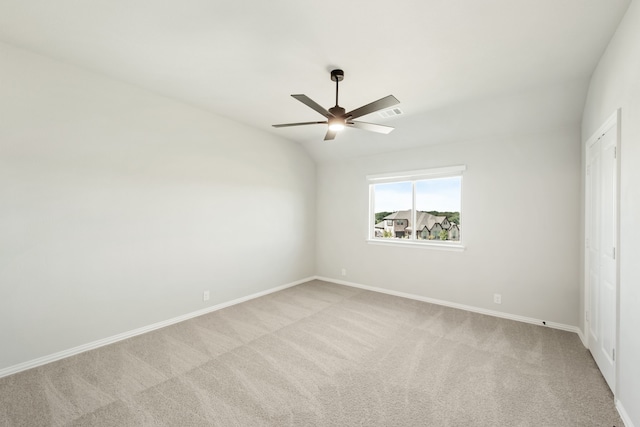 carpeted empty room featuring ceiling fan and vaulted ceiling