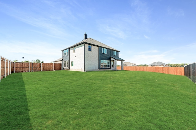 back of house with a lawn