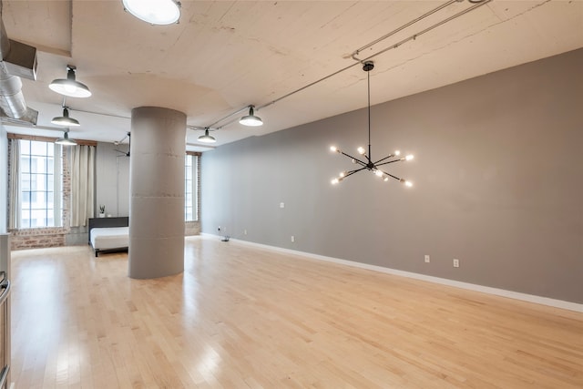 basement featuring a chandelier and light hardwood / wood-style flooring