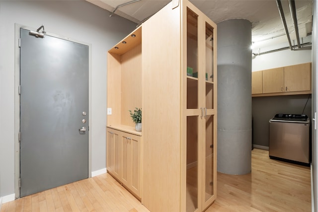 doorway with washer / dryer and light hardwood / wood-style flooring