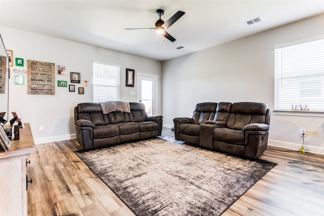 living room featuring wood-type flooring and ceiling fan