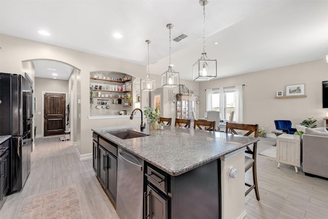 kitchen featuring pendant lighting, sink, a kitchen island with sink, built in shelves, and stainless steel dishwasher